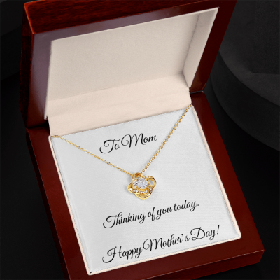 Gold heart-shaped necklace in a wooden box with a Mother's Day card.