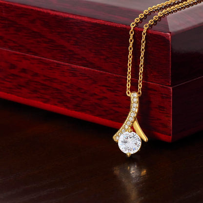 Alluring Beauty Necklace with ribbon-shaped pendant on adjustable chain next to luxury gift box